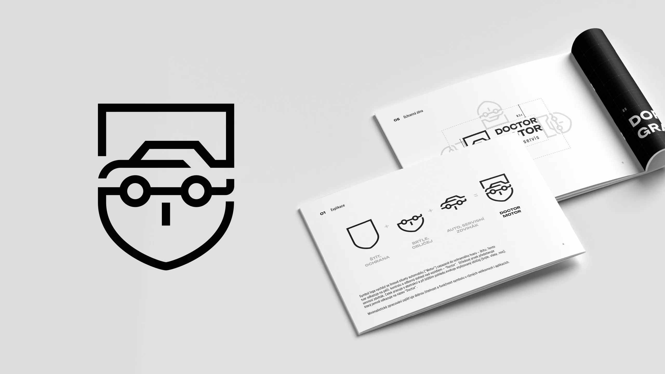 Grey brand manual spreads and a black poster tube with car and face line icons