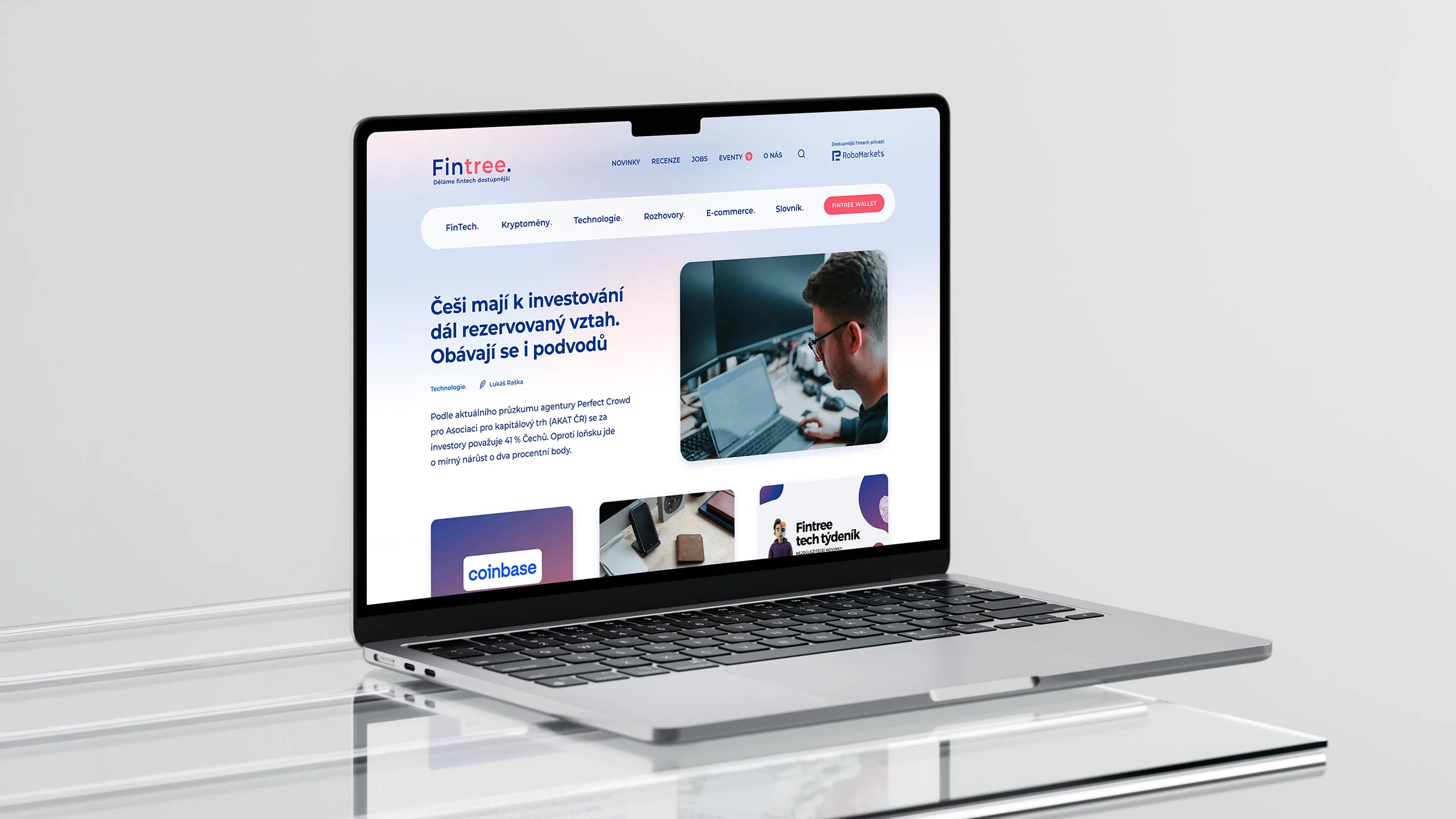 Laptop showing the Fintree website on a glass shelf in a light grey studio